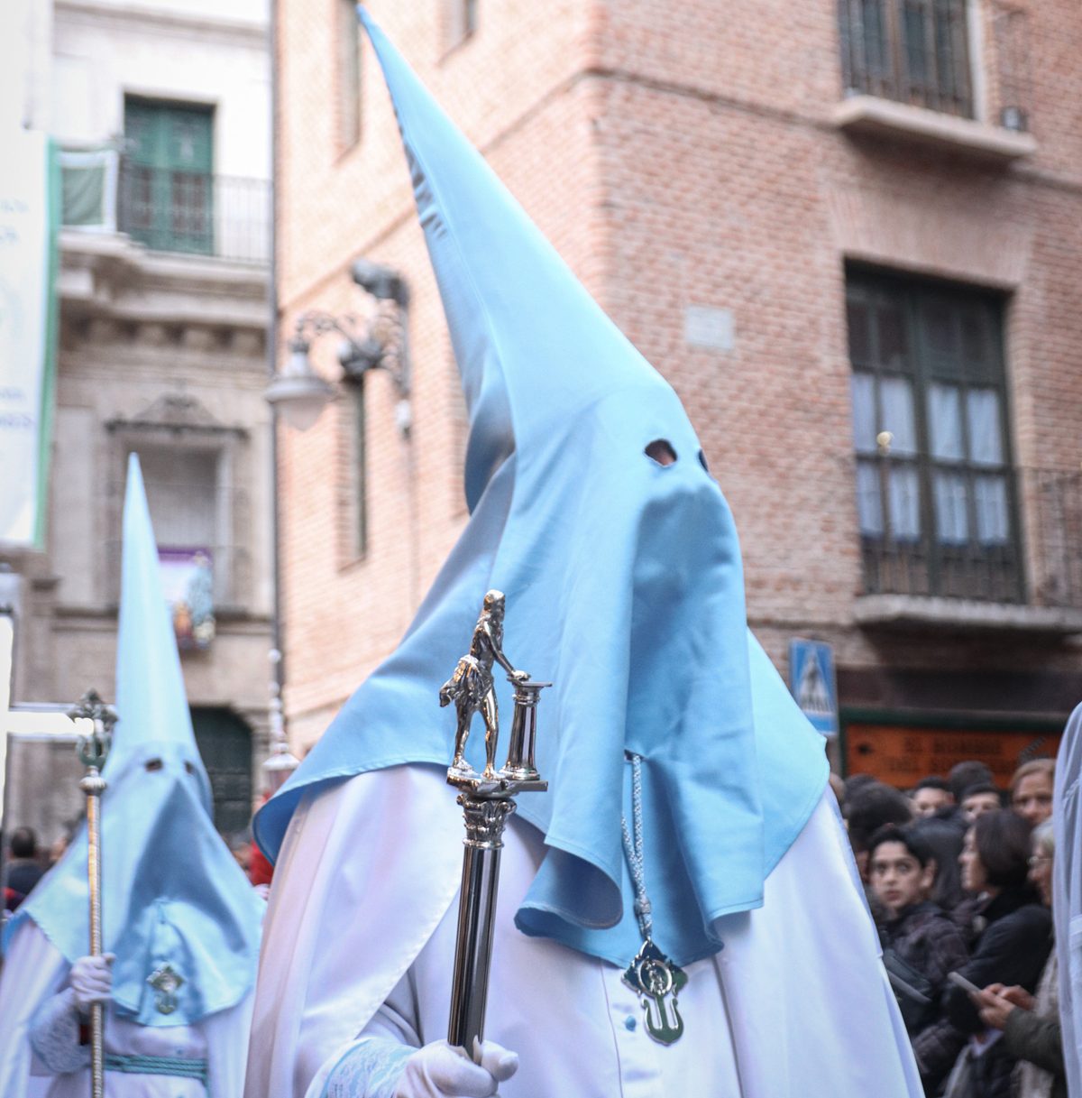 Cofrades con hábito blanco y capirote azul cielo